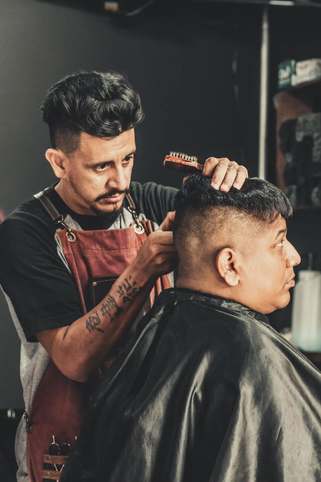 Barbeiro a pentear e cortar o cabelo de um cliente