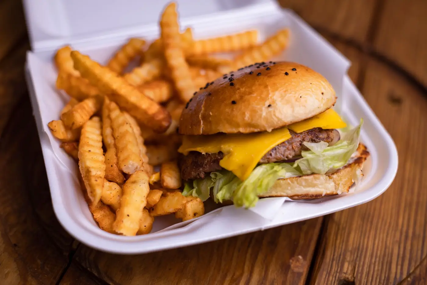 Cheeseburger com batatas onduladas numa caixa