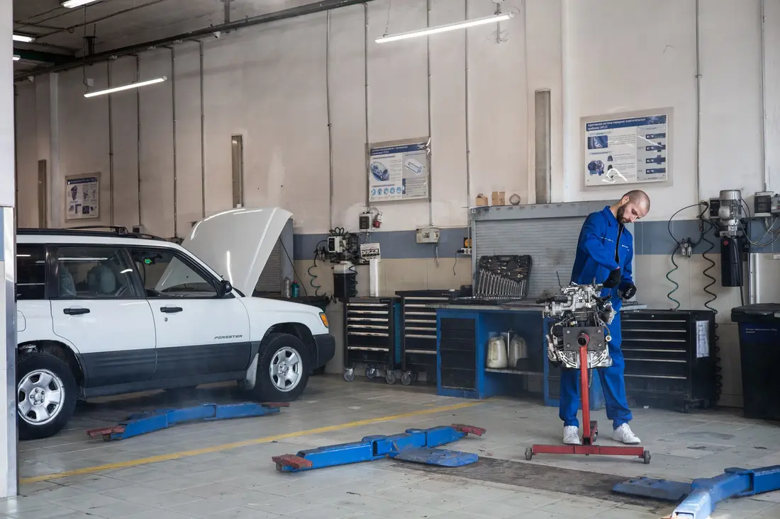 Interior da oficina com ferramentas e um carro em reparação
