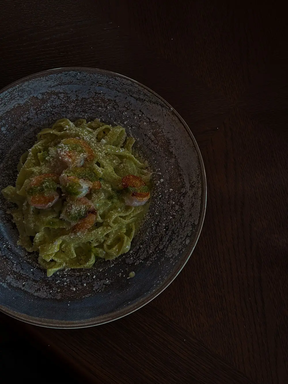 Tagliatelle com pesto num prato escuro