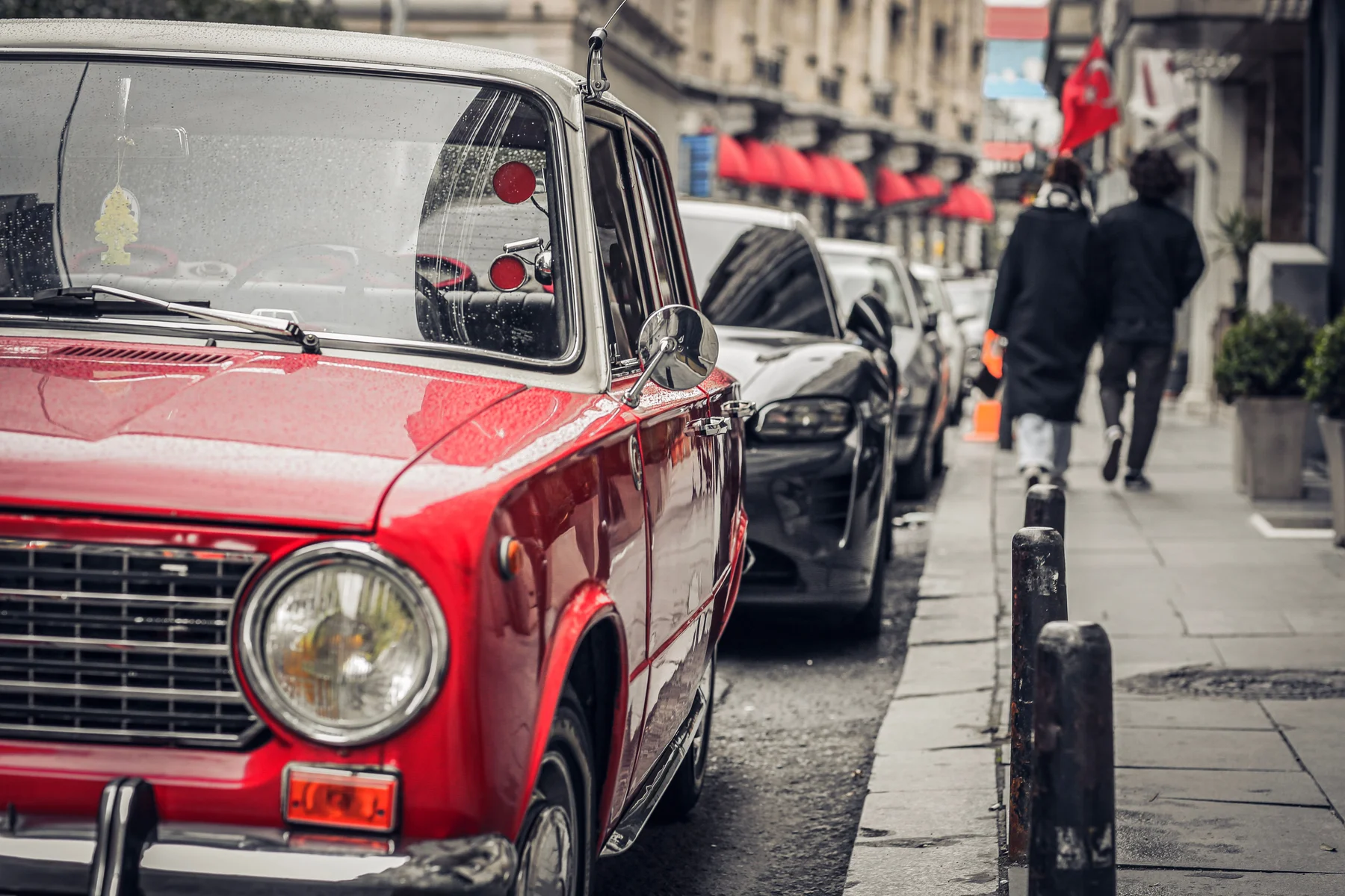 Carro clássico italiano vermelho estacionado numa rua