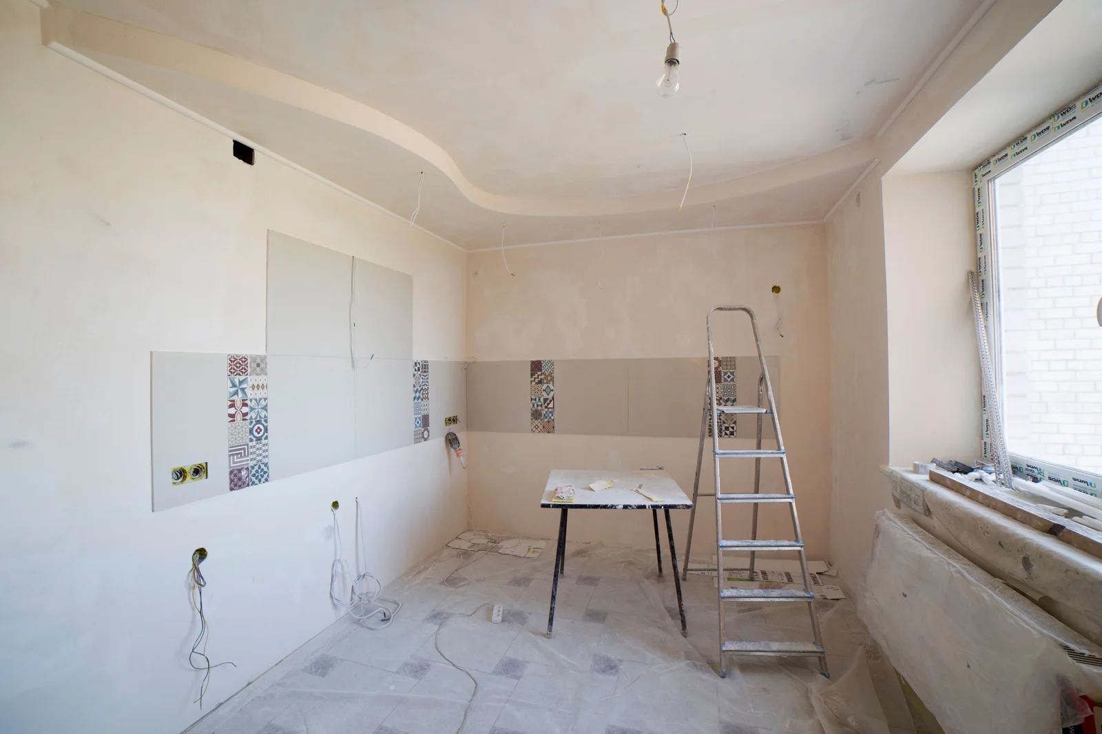 Cozinha em obra, sem móveis, com escadote