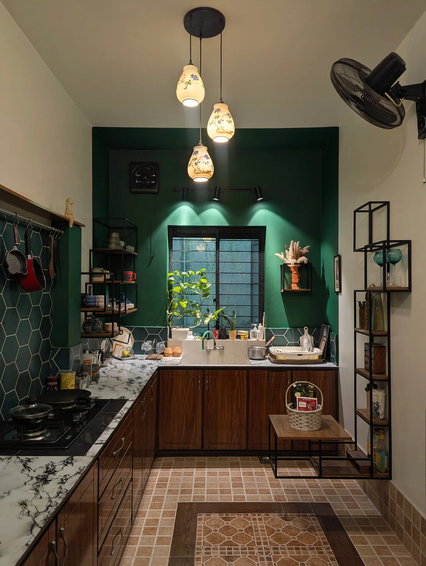 Cozinha remodelada com parede verde e candeeiros