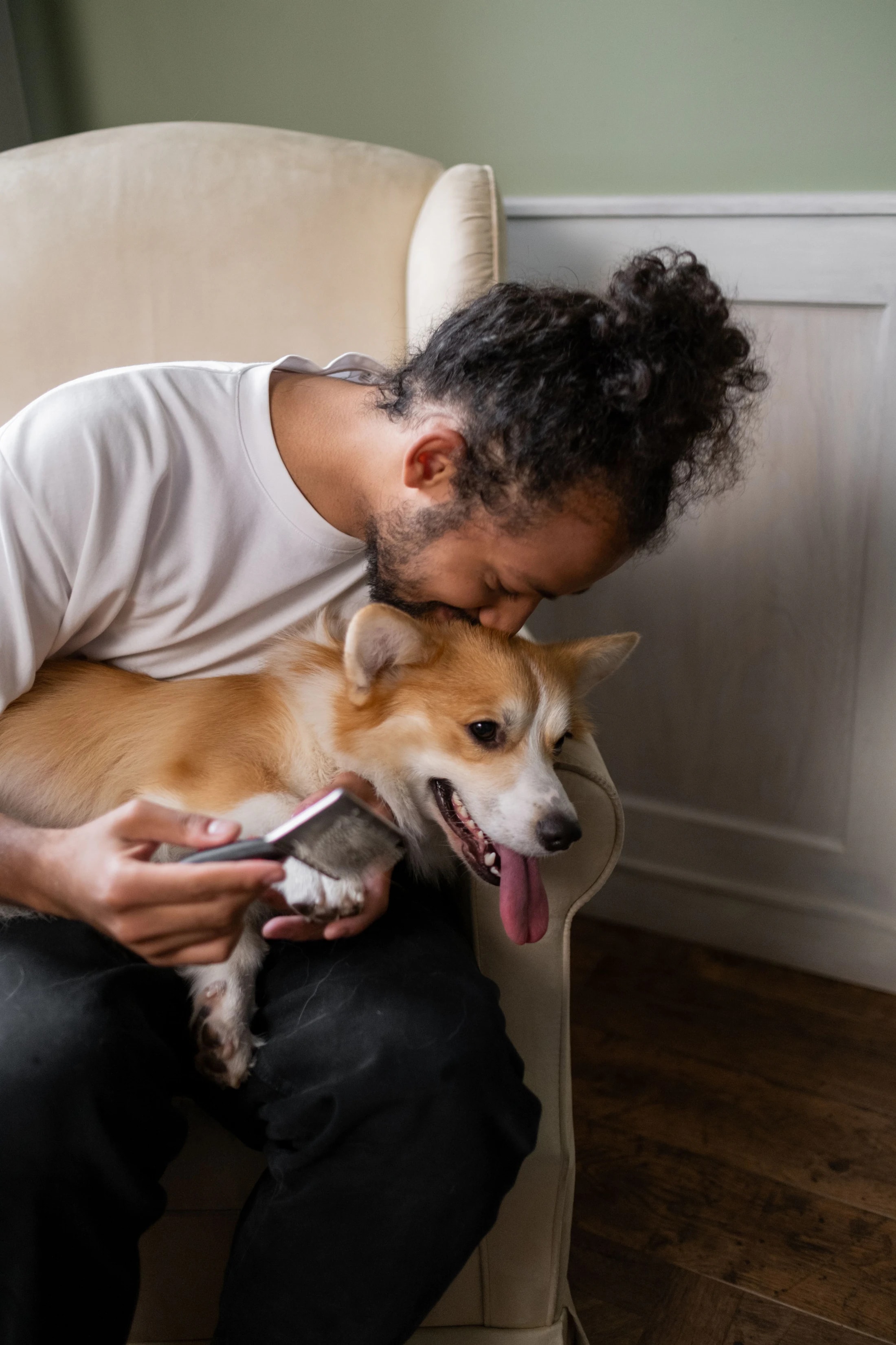 Homem a abraçar o seu corgi